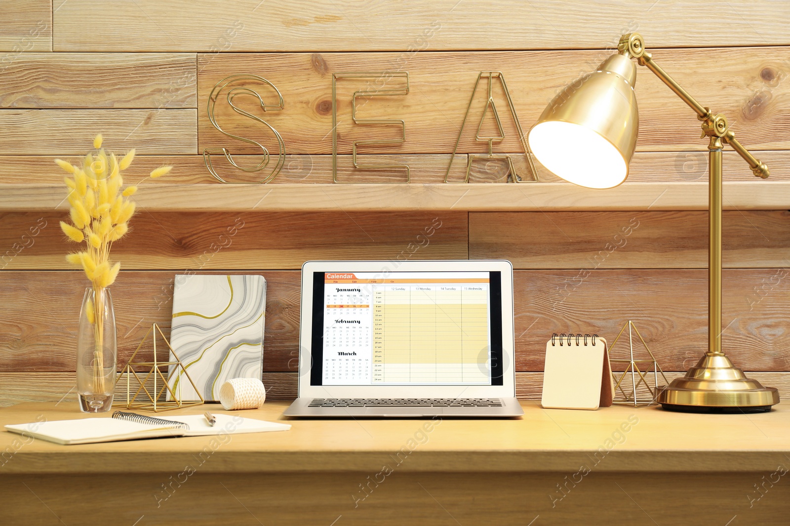 Photo of Modern laptop with calendar on screen in office