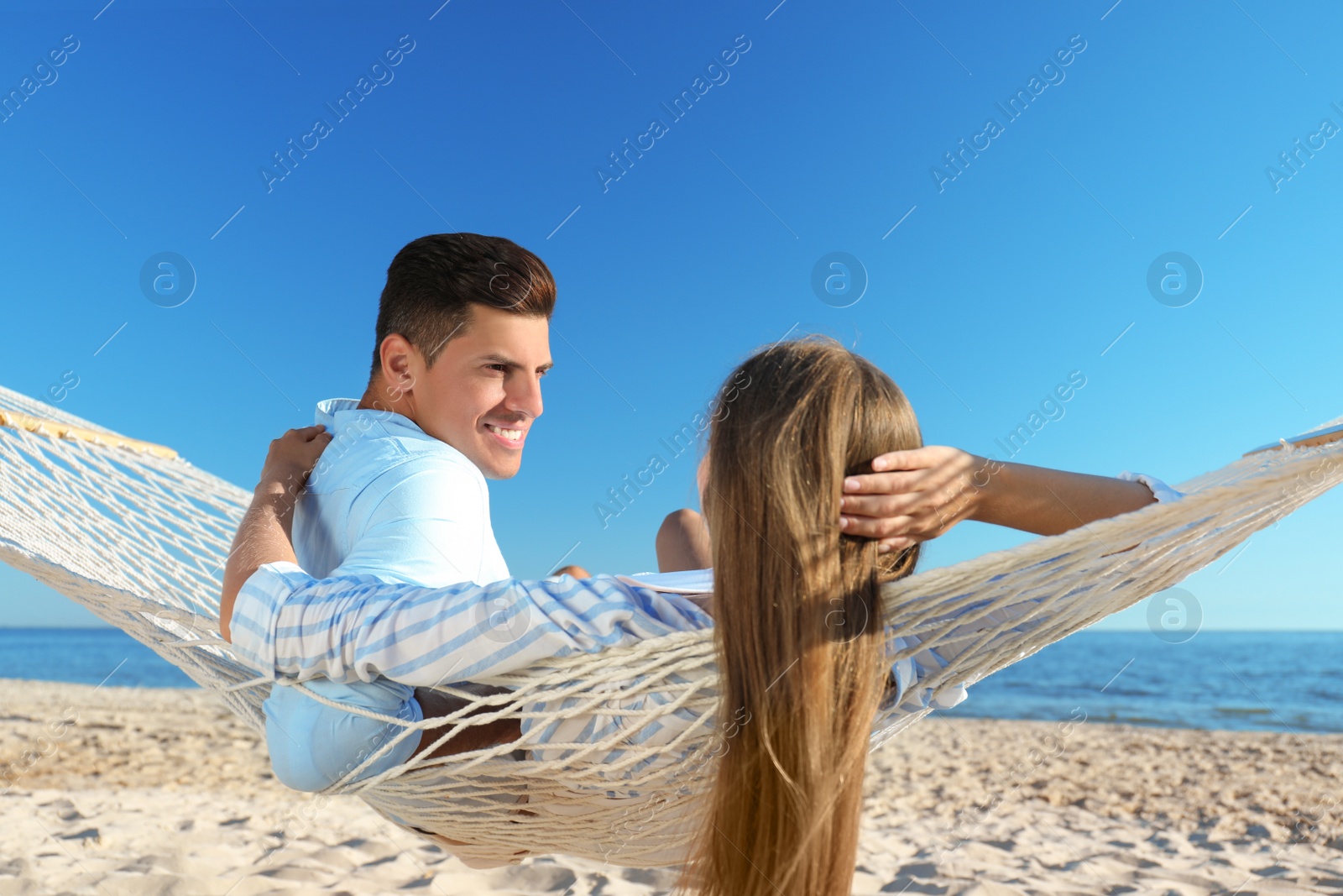 Photo of Happy couple relaxing in hammock on beach