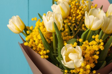 Bouquet of beautiful spring flowers near turquoise wooden wall, closeup