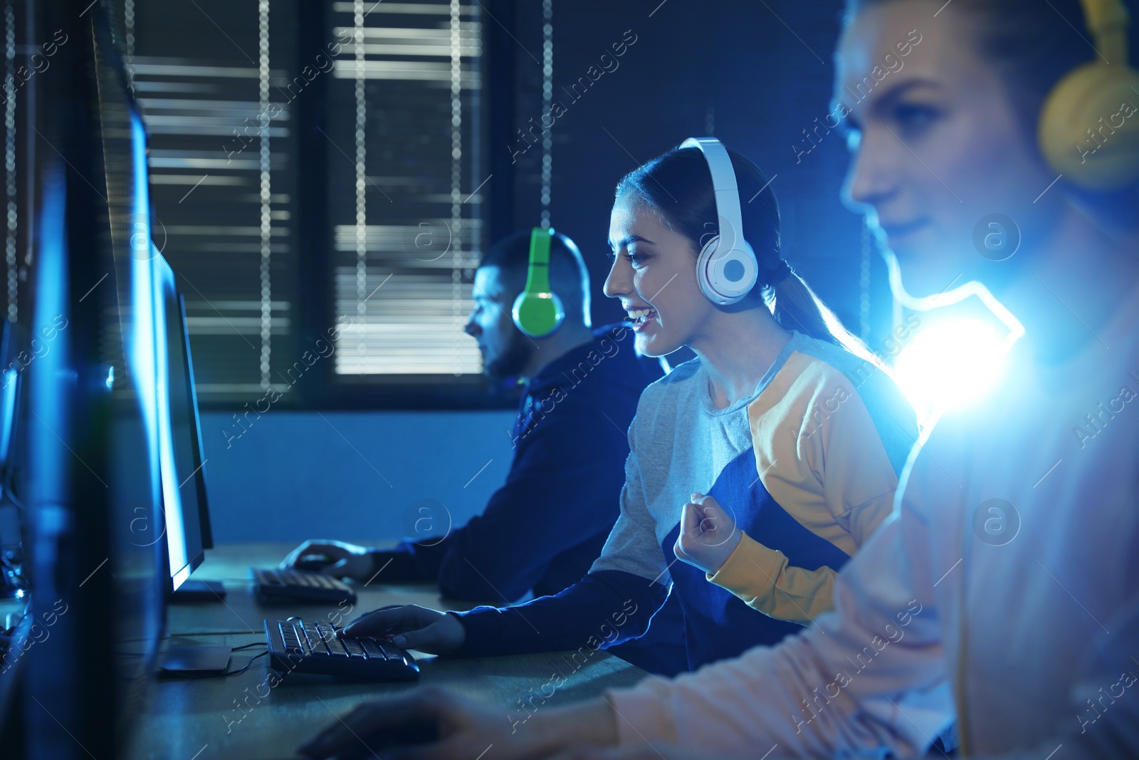 Photo of Group of people playing video games in internet cafe