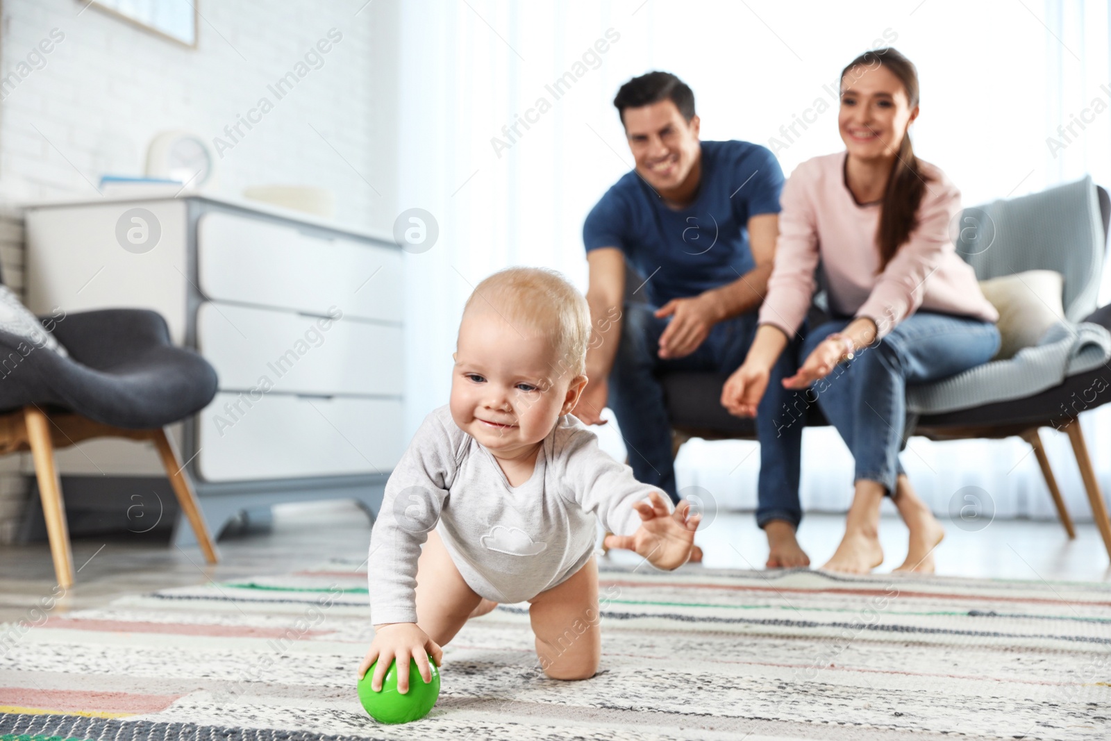 Photo of Adorable little baby crawling near parents at home