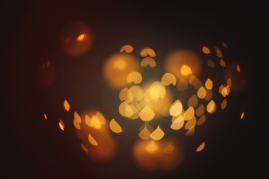 Photo of Blurred view of gold lights on dark background. Bokeh effect