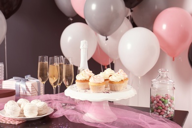 Party treats on table in room decorated with balloons