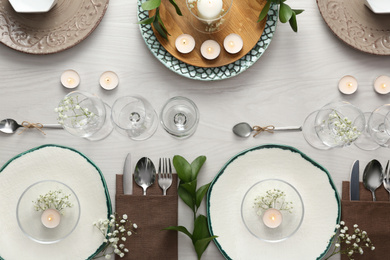 Photo of Elegant table setting with green plants on white wooden background, flat lay