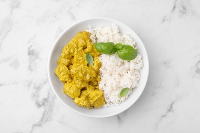 Photo of Delicious rice and chicken with curry sauce on white marble table, top view