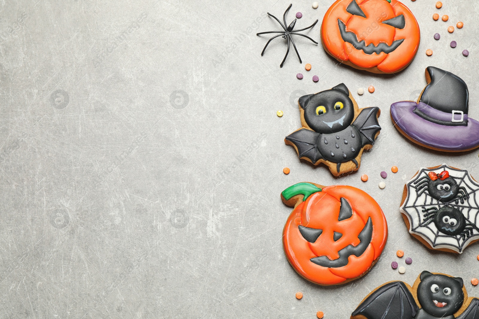 Photo of Tasty Halloween cookies on light grey table, flat lay. Space for text