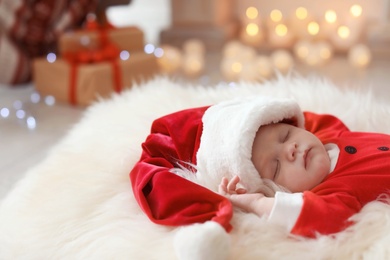 Photo of Cute baby in Christmas costume sleeping on fur rug