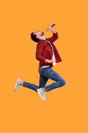 Photo of Handsome man with microphone singing and jumping on yellow background