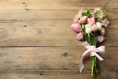 Photo of Happy Mother's Day. Bouquet of beautiful flowers tied with pink ribbon on wooden table, top view. Space for text