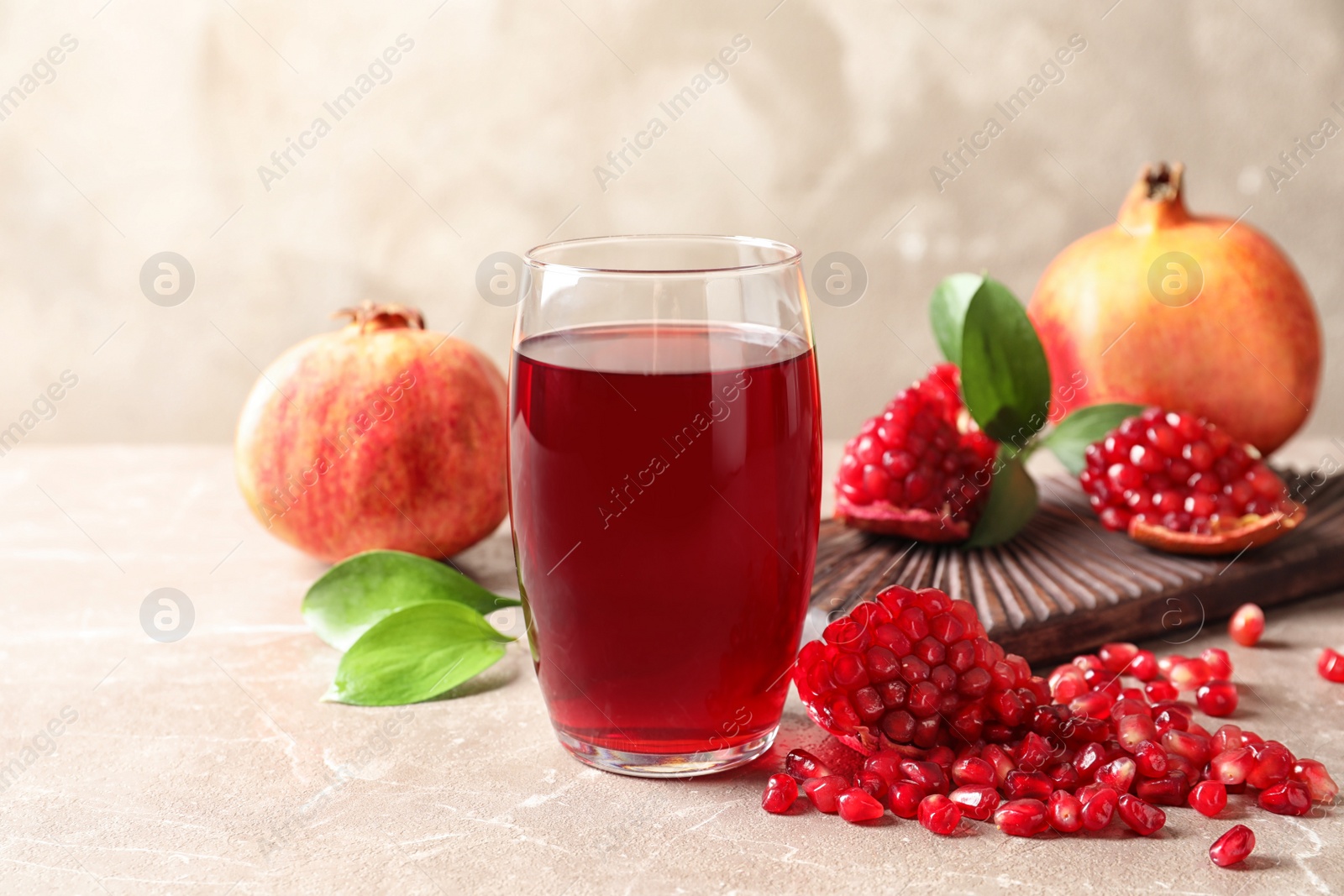 Photo of Composition with glass of fresh pomegranate juice on table