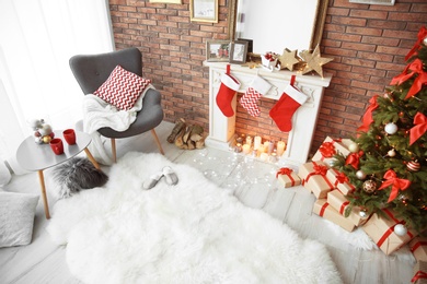 Photo of Room interior with beautiful Christmas tree and gifts near decorative fireplace