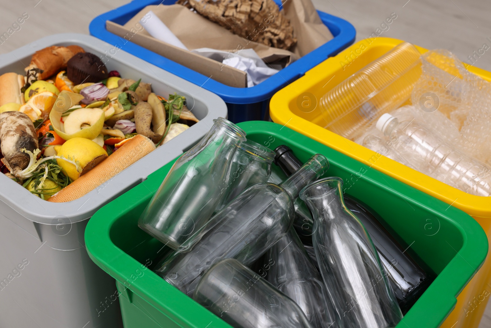 Photo of Garbage sorting. Full trash bins for separate waste collection indoors, closeup