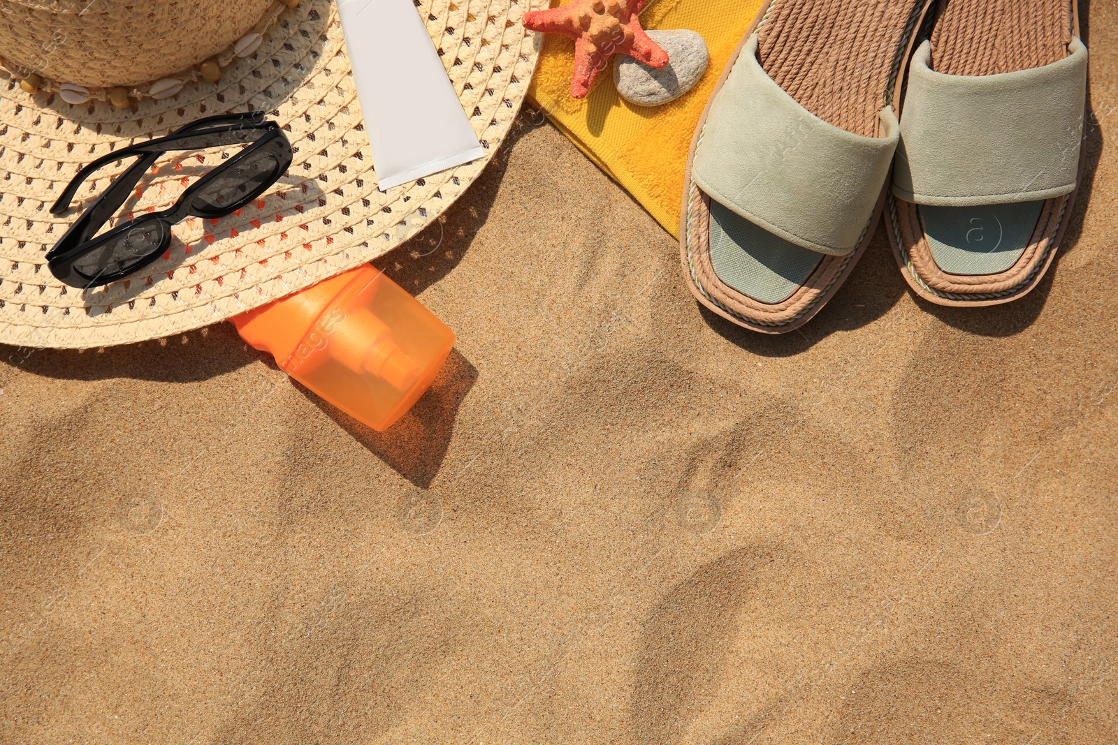 Photo of Flat lay composition with beach accessories on sand. Space for text