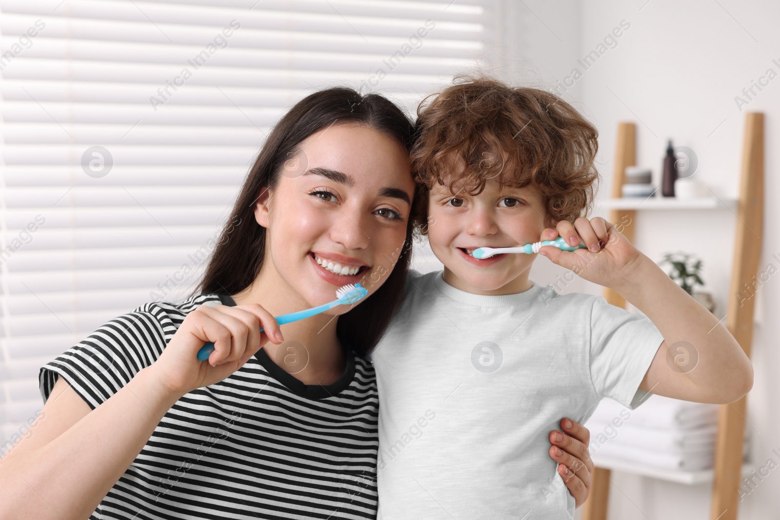 Photo of Mother and her son brushing teeth together in bathroom