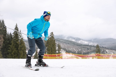 Photo of Male skier on slope at resort, space for text. Winter vacation