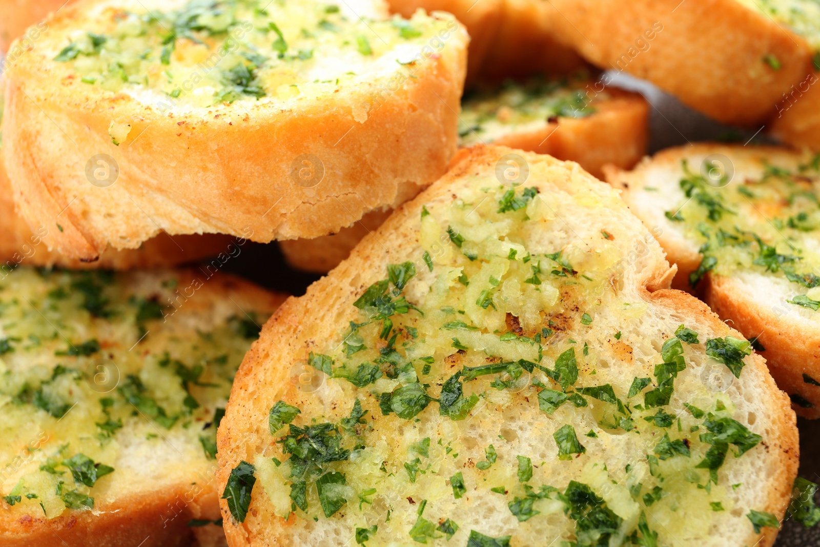 Photo of Slices of toasted bread with garlic and herbs as background, closeup