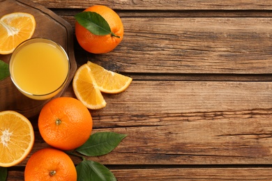 Orange juice and fresh fruits on wooden table, flat lay. Space for text