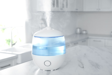 Photo of Modern air humidifier on table in kitchen