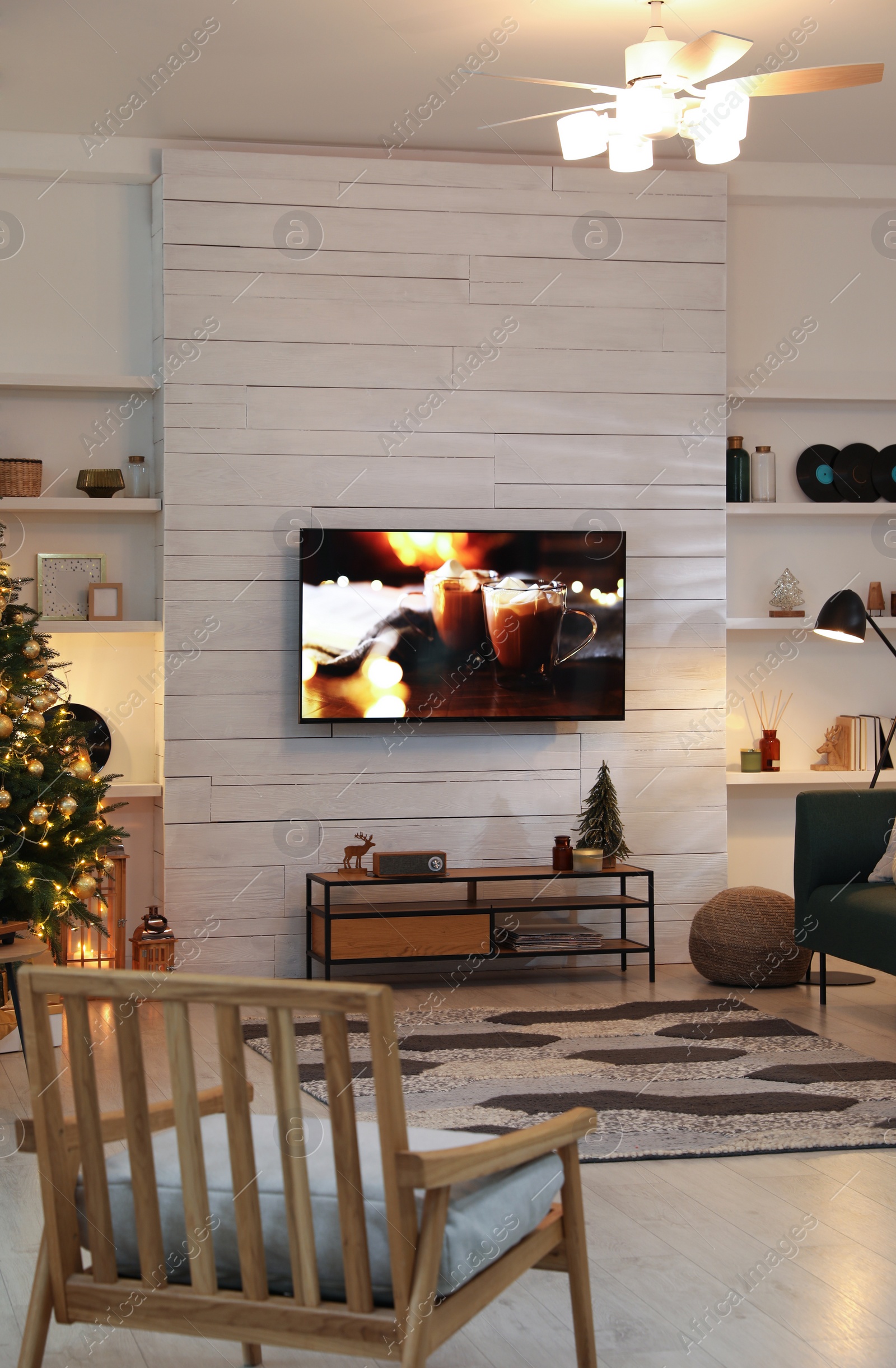 Photo of Plasma TV on white wooden wall in living room beautifully decorated for Christmas