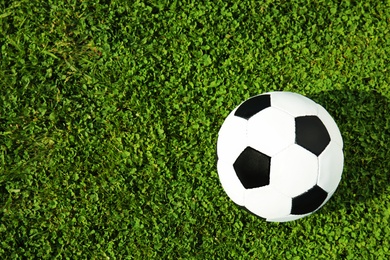 Photo of Soccer ball on fresh green football field grass, top view. Space for text