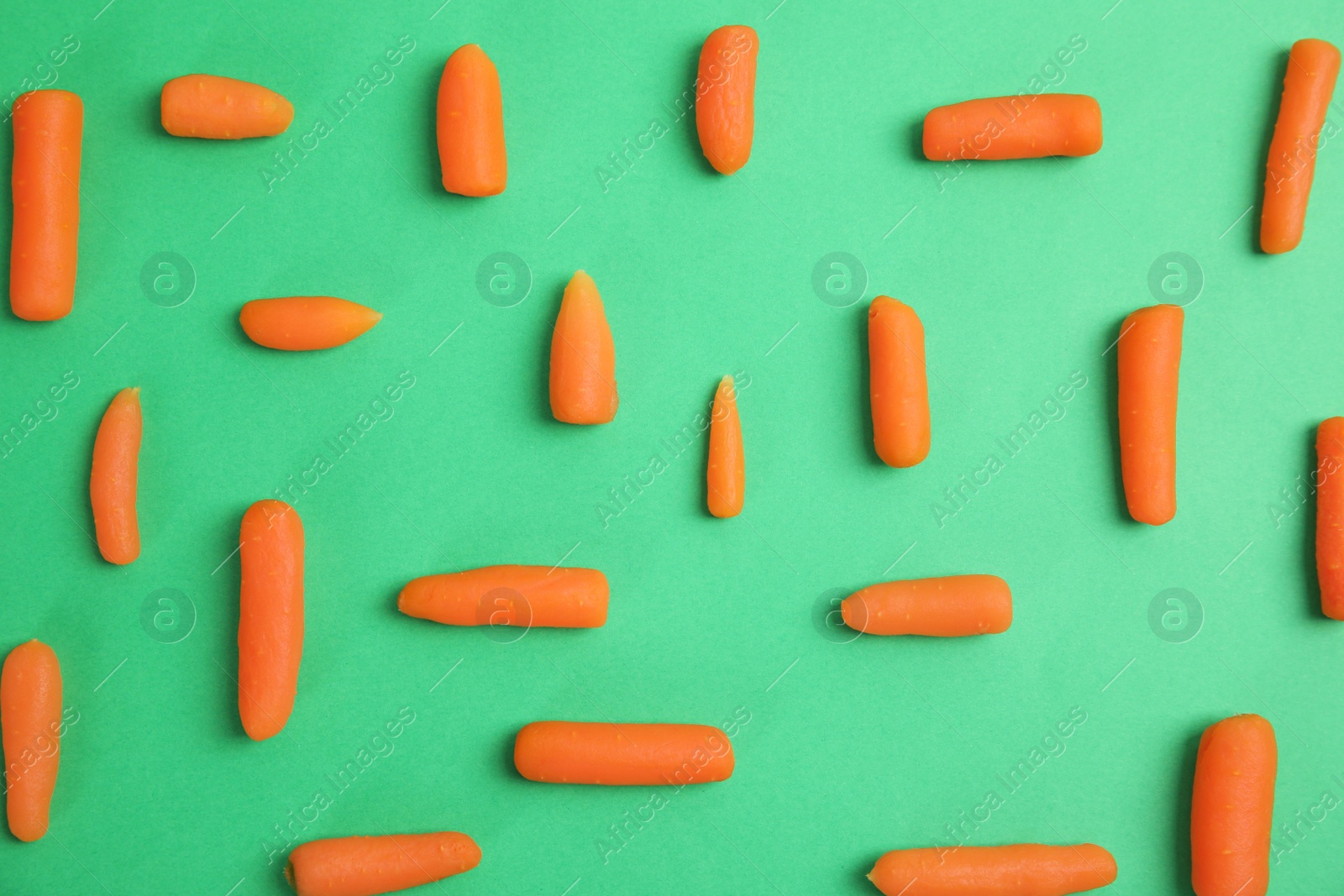 Photo of Flat lay composition with baby carrots on color background