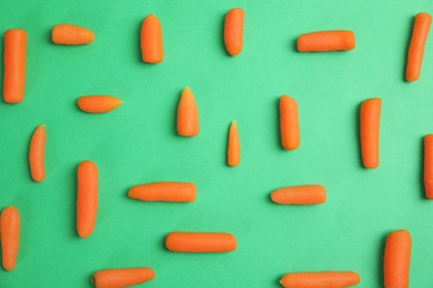 Photo of Flat lay composition with baby carrots on color background