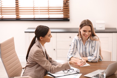 Female insurance agent consulting young woman in office