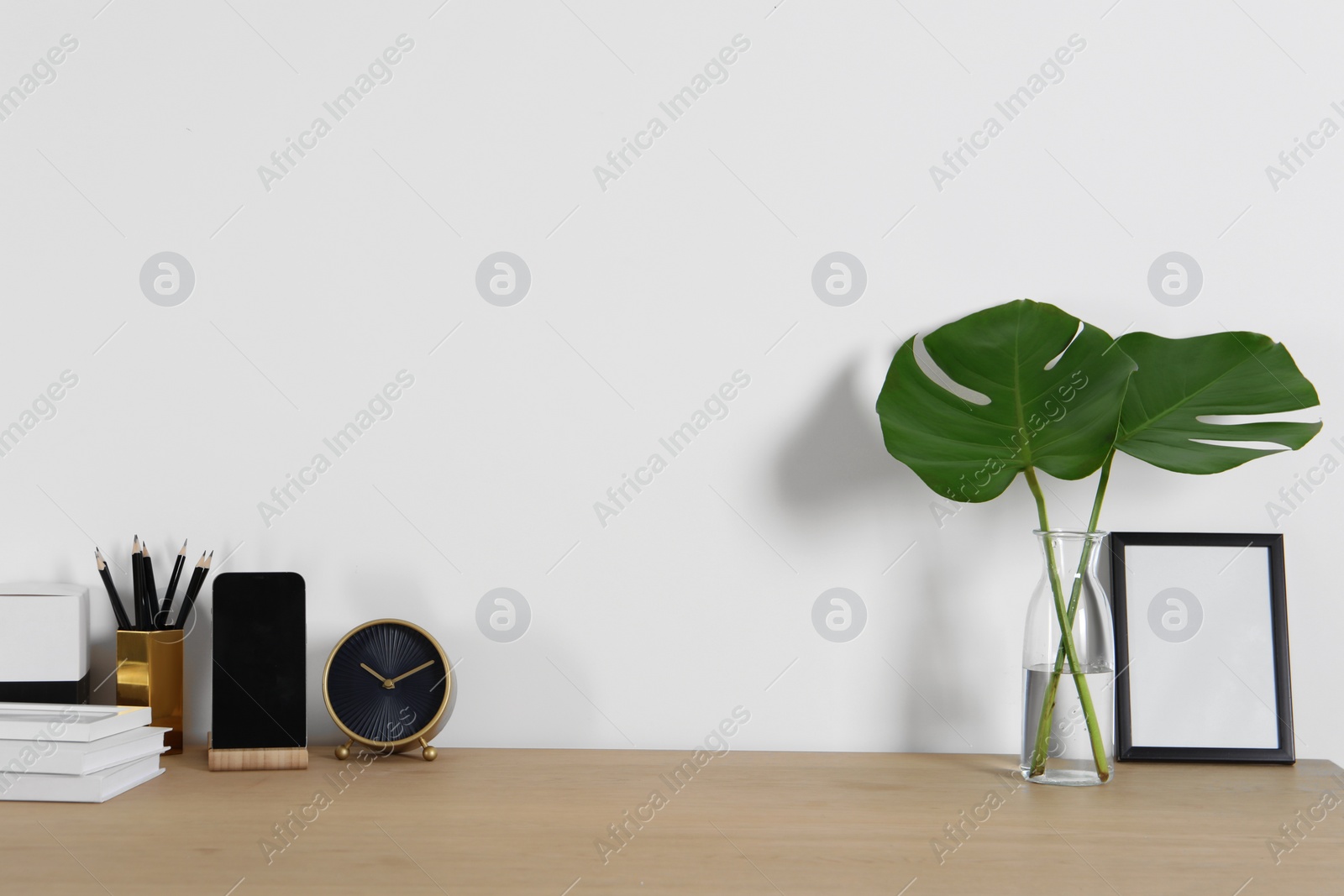 Photo of Comfortable workplace with wooden desk near white wall at home