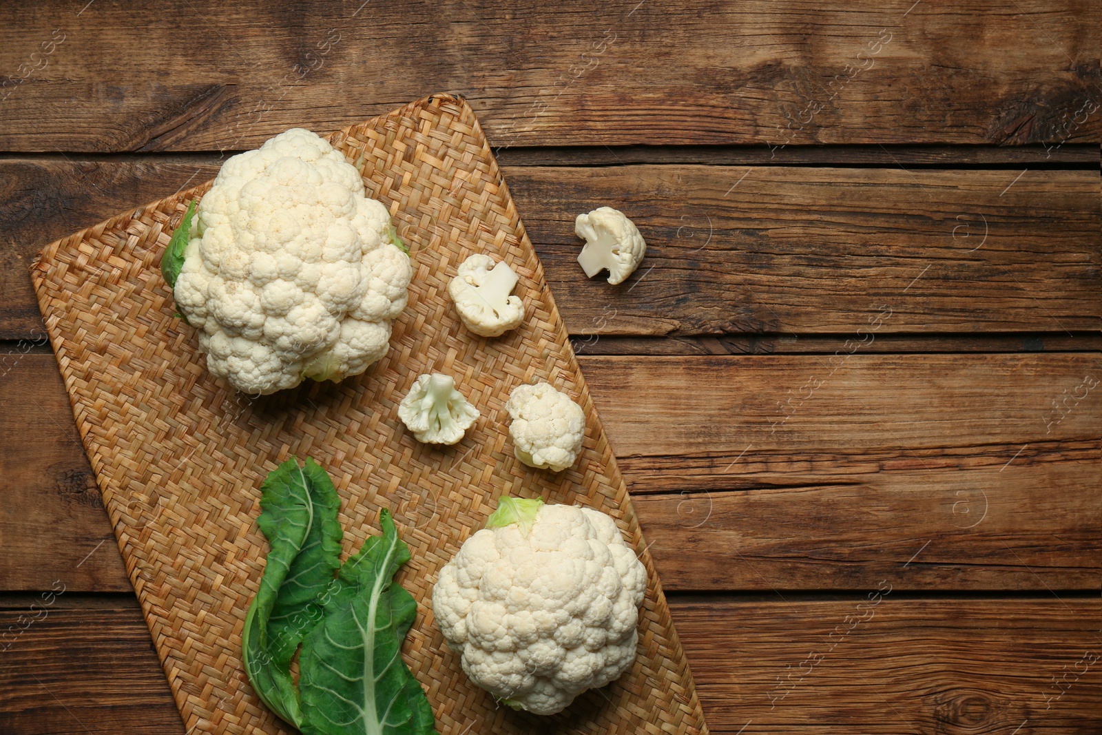 Photo of Fresh cauliflower on wooden table, top view. Space for text