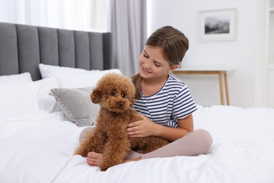 Photo of Little child with cute puppy on bed at home. Lovely pet