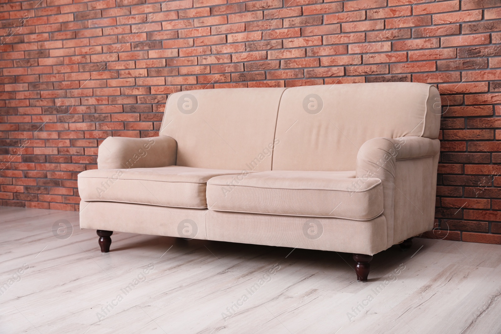 Photo of Room interior with comfortable sofa near brick wall