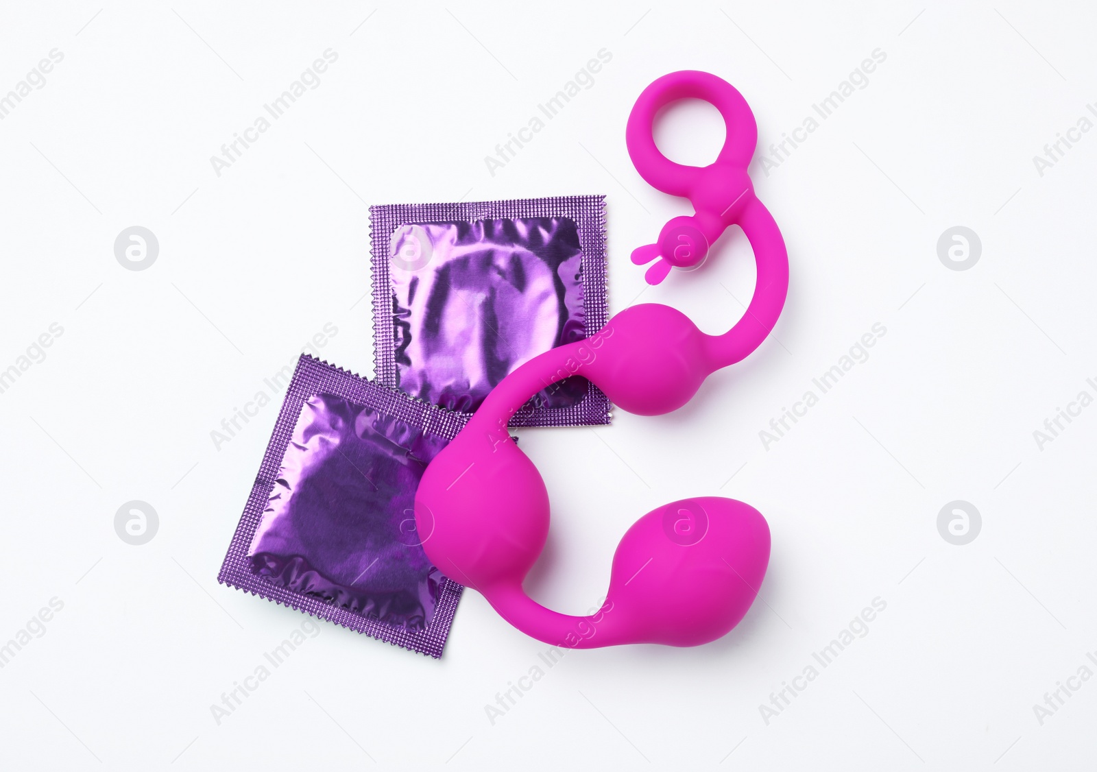 Photo of Anal balls and condoms on white background, top view. Sex game