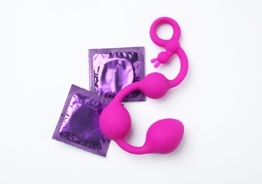 Photo of Anal balls and condoms on white background, top view. Sex game