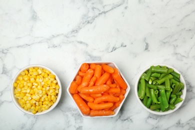 Photo of Flat lay composition with frozen vegetables on marble background