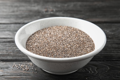 Photo of Bowl with chia seeds on wooden background