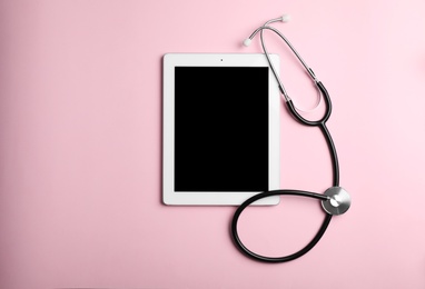 Photo of Stethoscope and tablet with space for text on color background, top view. Medical device