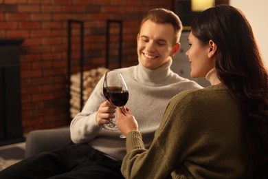 Happy lovely couple with glasses of wine resting together at home