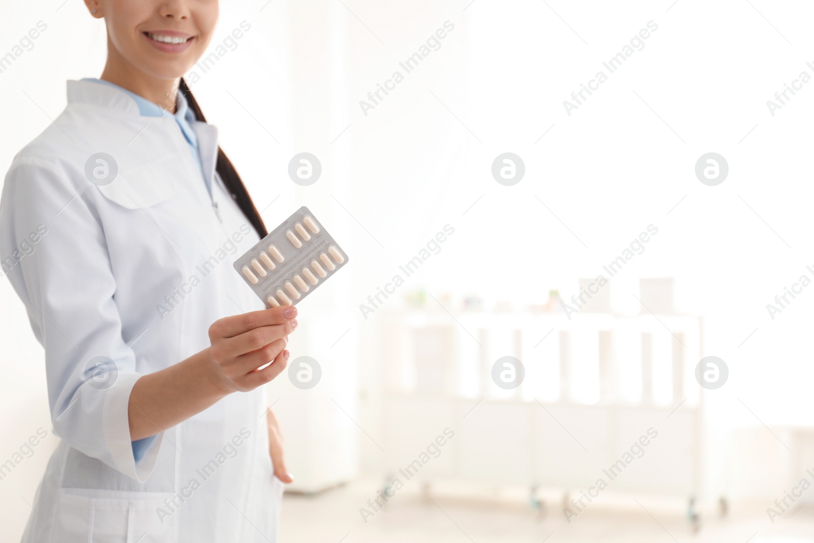 Photo of Professional pharmacist with pills in drugstore, closeup. Space for text