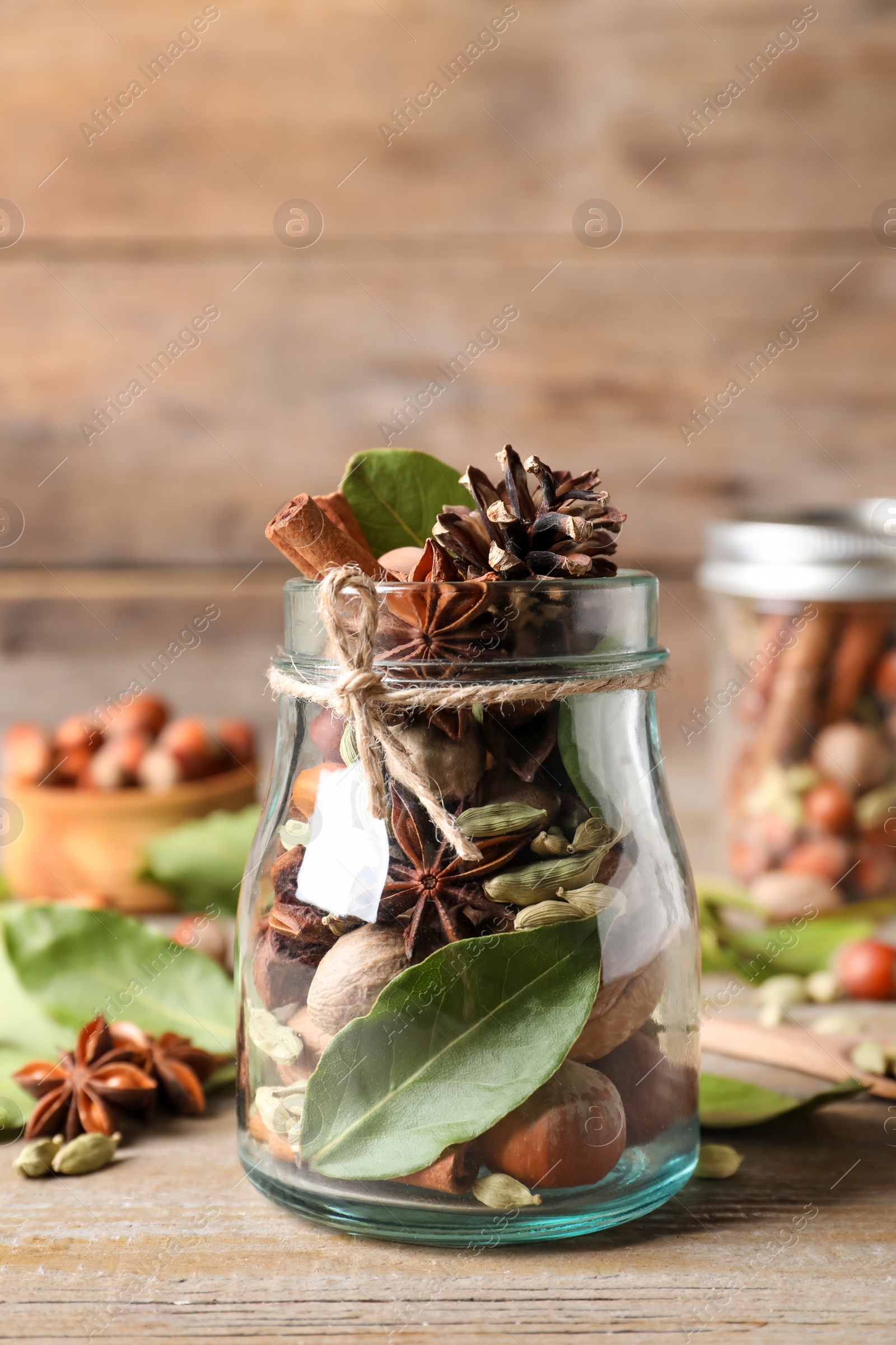 Photo of Aromatic potpourri in glass jar on wooden table