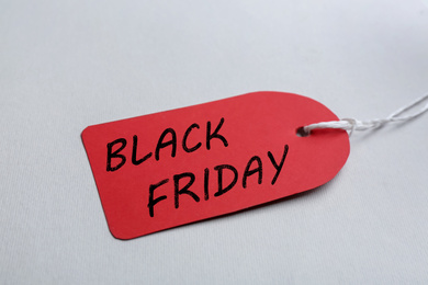 Photo of Red blank tag on light background, closeup. Black Friday concept