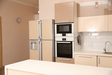 Interior of spacious modern kitchen with refrigerator