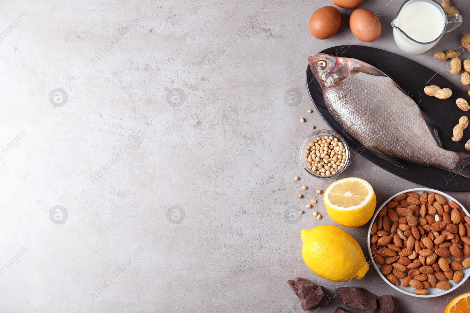 Photo of Flat lay composition of different products and space for text on gray table. Food allergy concept