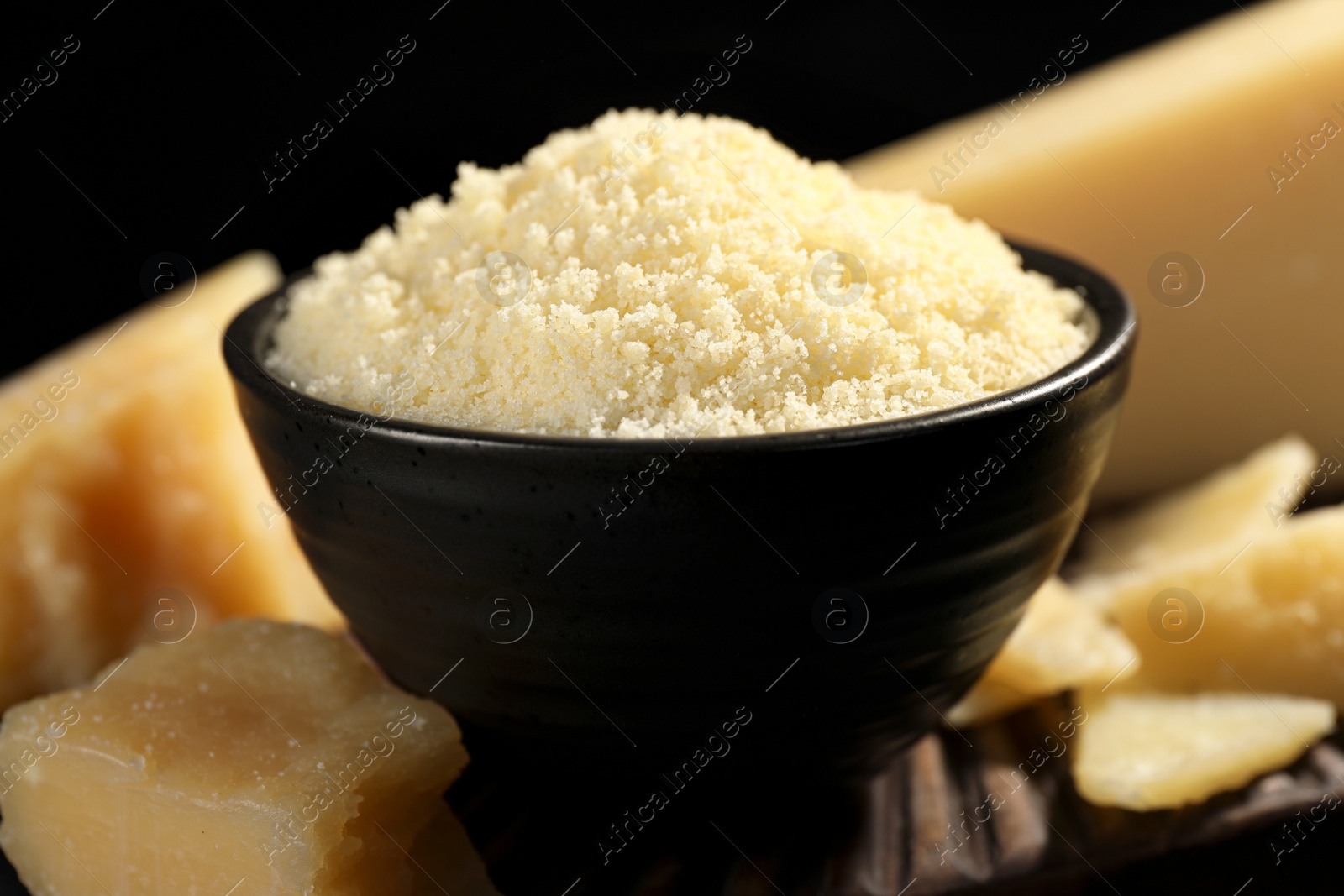 Photo of Bowl with grated parmesan cheese on table, closeup