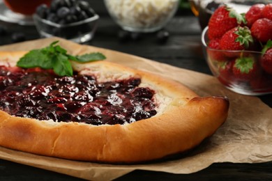 Delicious sweet cottage cheese pastry with cherry jam served on wooden table, closeup