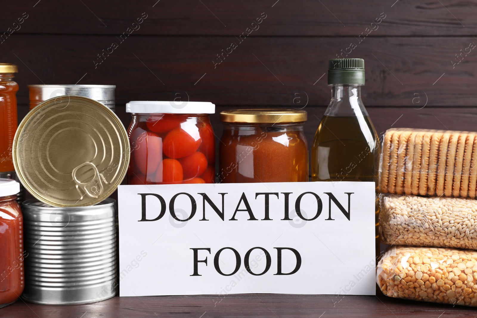 Photo of Card with words Donation Food and different products on wooden table