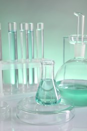 Photo of Laboratory analysis. Different glassware on table against color background