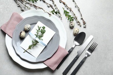 Photo of Festive Easter table setting with quail eggs on color background, flat lay