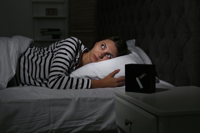 Young woman suffering from insomnia in bed at home