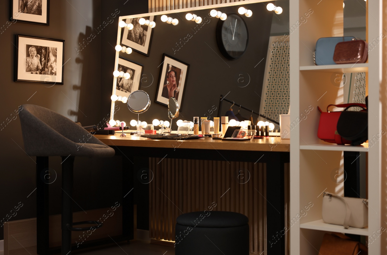 Photo of Makeup room. Stylish mirror on dressing table with different beauty products