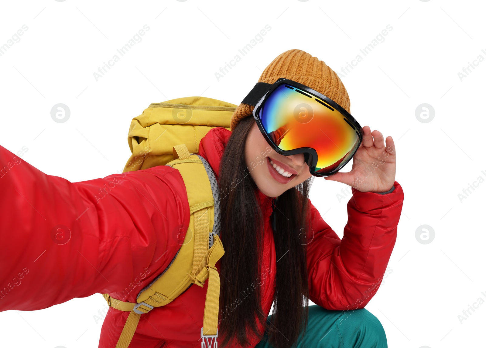 Photo of Smiling woman in ski goggles taking selfie on white background